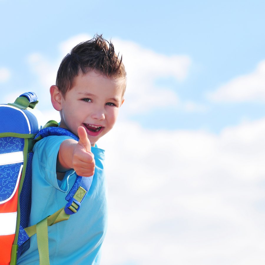 Schulkind mit Schulrucksack streckt den Arm mit ausgestrecktem Daumen zur Kamera, Bild: Natallia Vintsik - stock.adobe.com